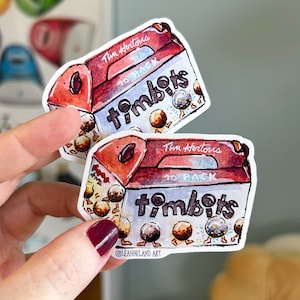 Può includere: Due adesivi raffiguranti un'illustrazione ad acquerello di una scatola di Timbits Tim Hortons. La scatola è rossa e bianca con le parole "Tim Hortons" e "Timbits" stampate sopra. Gli adesivi sono tenuti da una persona.