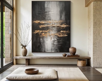May include: Abstract painting with black, white, and gold accents. The painting is displayed on a wall in a modern living room setting.