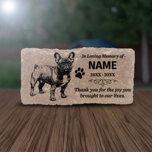 May include: A rectangular stone memorial with a detailed black engraving of a French Bulldog. The text reads "- In Loving Memory of- NAME 20XX-20XX Thank you for the joy you brought to our lives." A paw print is also included.