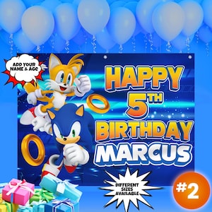 May include: Blue and orange birthday banner featuring Sonic the Hedgehog and Tails. The banner says "Happy 5th Birthday Marcus" and has a blue and white background with a sparkle effect.