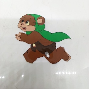 May include: A brown and green cartoon character with a green hooded cloak running to the right. The character has large ears and a small tail.