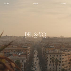 May include: A cityscape viewed from above, bathed in a warm, golden light. The image features the text "DEL & VO" with "EST. 2024" below. The words "CURATED", "TIMELESS", and "ELEGANT" are displayed at the top of the image.