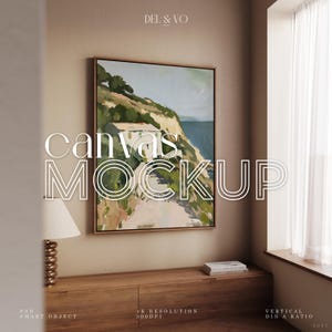 Puede incluir: Maqueta de lienzo enmarcado con el texto "canvas MOCKUP". La obra de arte representa un paisaje costero con colinas verdes, edificios blancos y agua azul. La escena está ambientada en una habitación con un mueble de madera y una ventana.