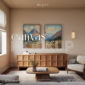May include: A living room scene featuring a wooden cabinet, coffee table, and armchair. Two framed landscape paintings hang above the cabinet. The words "canvas mockup" are displayed in large, white text. The room has a neutral color palette.