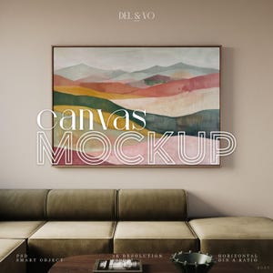 May include: A framed canvas art print with a landscape painting in shades of red, green, yellow, and gray. The text "CANVAS MOCKUP" is overlaid on the artwork. The artwork is displayed above a green sofa and a wooden coffee table.