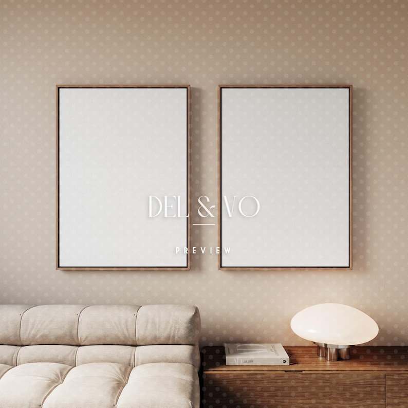 May include: Two framed blank canvases with wooden frames hang on a beige polka-dot wall. The text "DEL & VO PREVIEW" is visible on the canvases. A beige sofa and a wooden cabinet with a lamp are in the foreground.