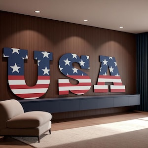 Peut inclure: Grandes lettres murales "USA" aux couleurs du drapeau américain : bleu étoilé et rayures rouges et blanches. L'ensemble est fixé sur un mur en bois, créant une décoration patriotique. Idéal pour un intérieur.