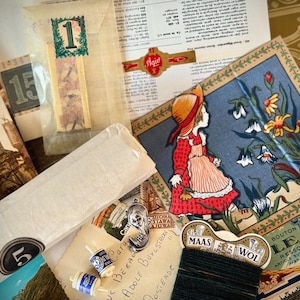 May include: A collection of vintage ephemera including a paper packet labeled 1, a card featuring a girl in a red dress among flowers, a spool of black thread labeled Maas Wol, two small blue and white thread bobbins, and a silver metal charm.