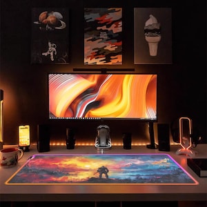 May include: A colorful, abstract design mousepad with a glowing edge. The mousepad features a landscape scene with a lone figure standing in the foreground. The mousepad is illuminated with a rainbow of colors.