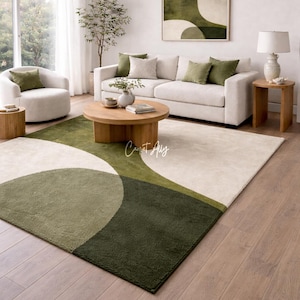 Hand tufted abstract area rug in olive green and ivory with organic curved design placed in a modern living room. Soft textured rug with nature inspired pattern and neutral tones, ideal for contemporary home décor, minimalist interiors, and living room styling.