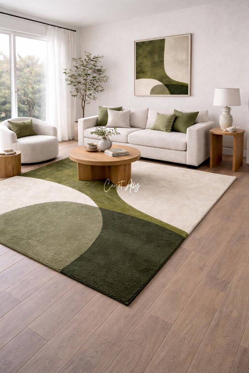 Hand tufted abstract area rug in olive green and ivory with organic curved design placed in a modern living room. Soft textured rug with nature inspired pattern and neutral tones, ideal for contemporary home décor, minimalist interiors, and living room styling.