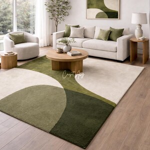Hand tufted abstract area rug in olive green and ivory with organic curved design placed in a modern living room. Soft textured rug with nature inspired pattern and neutral tones, ideal for contemporary home décor, minimalist interiors, and living room styling.