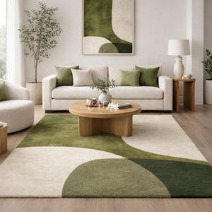 Hand tufted abstract area rug in olive green and ivory with organic curved design placed in a modern living room. Soft textured rug with nature inspired pattern and neutral tones, ideal for contemporary home décor, minimalist interiors, and living room styling.