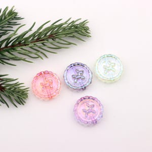May include: Four iridescent glass buttons with a star design. The buttons are in shades of pink, purple, and blue.
