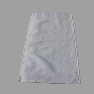 May include: A white hand towel with a soft, fluffy texture. The towel is folded and ready to be used.