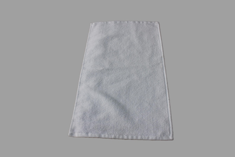 May include: A white hand towel with a soft, fluffy texture. The towel is folded and ready to be used.