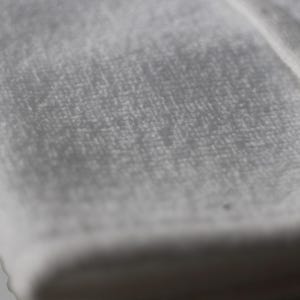 May include: Close-up of a white, soft, and textured fabric. The fabric has a smooth, even surface with a subtle sheen.