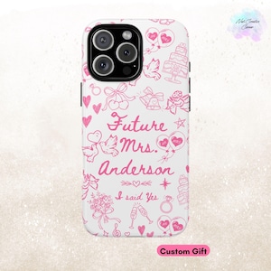May include: White iPhone case with a pink and white design. The design features a variety of wedding-themed illustrations, including hearts, doves, rings, and a cake. The text "Future Mrs. Anderson" and "I said Yes" are also included in the design.