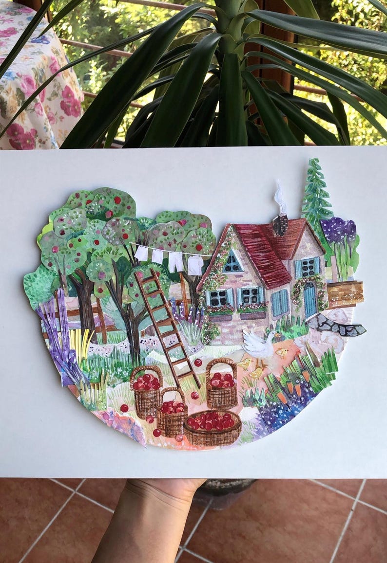 May include: A layered paper collage artwork depicting a cottage with a red roof, a wooden ladder, and a clothesline. The scene includes apple trees, baskets filled with red apples, a white goose with chicks, and a garden with various plants.