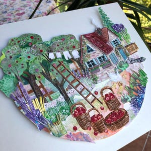 May include: A layered paper collage artwork depicting a rural scene with a cottage, apple trees, and a wooden ladder. The image features three woven baskets filled with red apples, a white goose with chicks, laundry on a line, and green foliage.