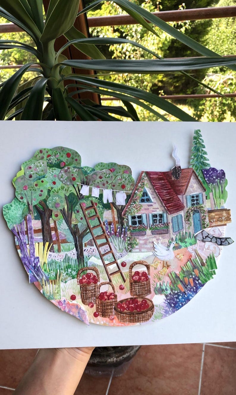 May include: A layered paper collage illustration depicting a cottage with a red roof, a wooden ladder, and apple trees. Baskets filled with red apples sit on the ground near a white goose and chicks. A clothesline with white laundry hangs nearby.