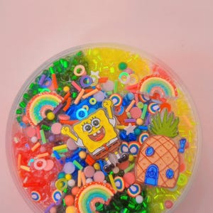 Ich bin bereit zum Knuspern, Regenbogen-Bingsu-Schleim. Spongebob-Anhänger, duftende Ananas und Kokosnuss