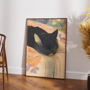 Puede incluir: Una pintura enmarcada de un gato negro durmiendo sobre una almohada con estampado floral de colores. Los ojos del gato est&aacute;n cerrados y sus bigotes son visibles. El fondo es un lavado de colores suave, como de acuarela.