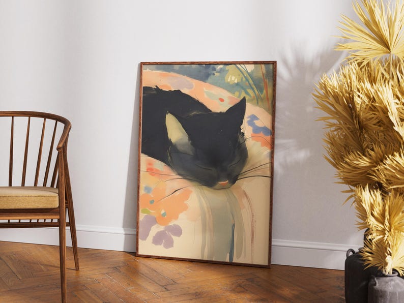 Puede incluir: Una pintura enmarcada de un gato negro durmiendo sobre una almohada con estampado floral de colores. Los ojos del gato est&aacute;n cerrados y sus bigotes son visibles. El fondo es un lavado de colores suave, como de acuarela.