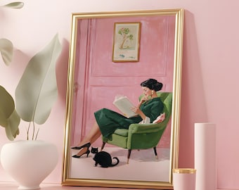 May include: A framed art print depicts a woman in a green dress reading in a green armchair, with a black cat at her feet. The artwork has a gold frame and is set against a pink background. A white vase and pink candle holder are in the foreground.