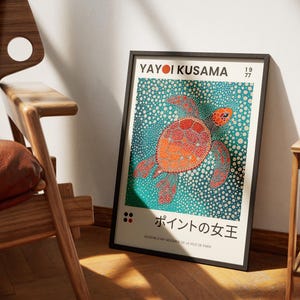 May include: A black framed poster with a colorful illustration of a sea turtle on a blue background. The poster features the text "Yayoi Kusama" and "1977" in the top right corner. The text "ポイントの女王" is in the bottom center of the poster.