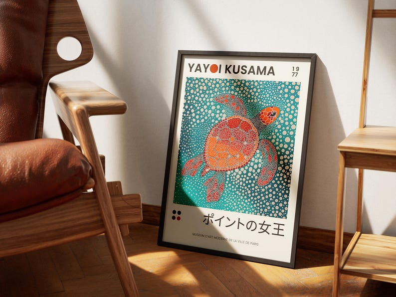 May include: A black framed poster with a colorful illustration of a sea turtle on a blue background. The poster features the text "Yayoi Kusama" and "1977" in the top right corner. The text "ポイントの女王" is in the bottom center of the poster.