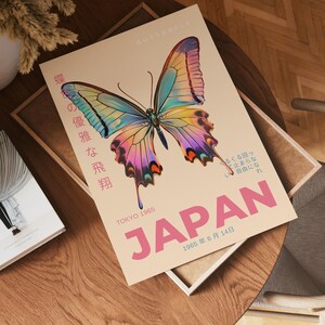 May include: A vintage poster with a colorful butterfly illustration and the text "BUTTERFLY" and "JAPAN" in pink. The poster also includes the text "TOKYO 1965" and "1965年6月14日" in black.