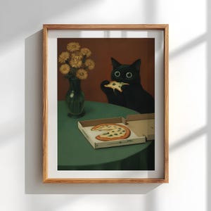 May include: A framed print featuring a black cat eating pizza. The cat has large, round eyes and is positioned near a pizza box on a green table. A vase of yellow flowers sits to the left.