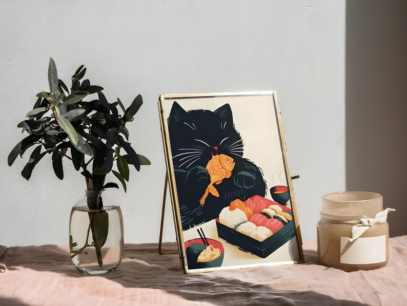 May include: A black cat with white whiskers is eating a fish and sushi from a black and white takeout container. The cat is in a gold frame on a pink table cloth. There is a clear glass vase with green leaves and a brown candle with a white label on the table.