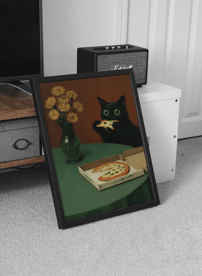 May include: Framed art print featuring a black cat eating pizza. The cat is depicted with large green eyes, sitting at a green table with a pizza box and a vase of yellow flowers. The background is a warm brown.