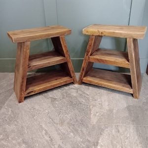 May include: Two wooden side tables with a rustic design. Each table features a rectangular top, a shelf, and angled legs. The wood has a natural, weathered look, with visible grain and knots. The tables are suitable for indoor use.