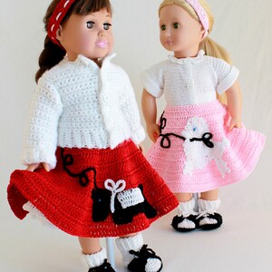 May include: Two dolls wearing crocheted outfits. The doll on the left is wearing a white cardigan, a red skirt with a black poodle design, and black and white shoes. The doll on the right is wearing a white cardigan, a pink skirt with a white poodle design, and black and white shoes.