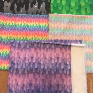 May include: Five different fabric swatches with various colorful patterns. The patterns include dripping slime, rainbows, and stars.