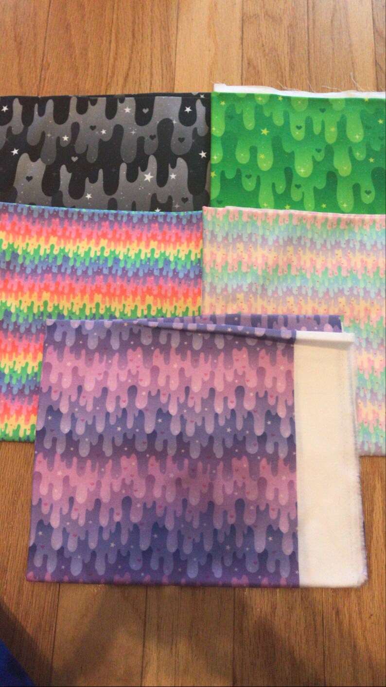 May include: Five different fabric swatches with various colorful patterns. The patterns include dripping slime, rainbows, and stars.