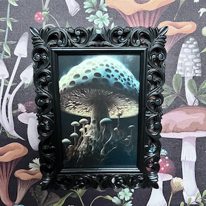 May include: A framed print of a large, blue and white mushroom with a dark brown stem and a glowing cap. The mushroom is surrounded by smaller mushrooms in a dark forest setting.