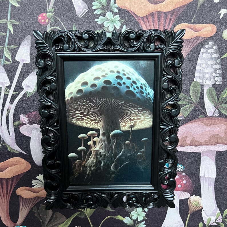 May include: A framed print of a large, blue and white mushroom with a dark brown stem and a glowing cap. The mushroom is surrounded by smaller mushrooms in a dark forest setting.