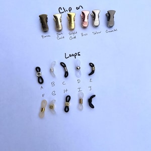 May include: A set of different colored metal clips for glasses, labeled "Clip on" with the colors bronze, dark gold, bright gold, rose, silver, and gunmetal. Below the clips are a variety of clear and black plastic loops for glasses, labeled "Loops" with letters A through J.