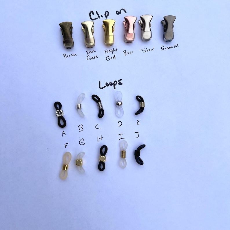 May include: A set of different colored metal clips for glasses, labeled "Clip on" with the colors bronze, dark gold, bright gold, rose, silver, and gunmetal. Below the clips are a variety of clear and black plastic loops for glasses, labeled "Loops" with letters A through J.