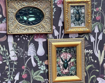 May include: Three framed insect art pieces with gold ornate frames. The art features a beetle, a bug, and a beetle with antlers. The background is a dark floral pattern with mushrooms and plants.