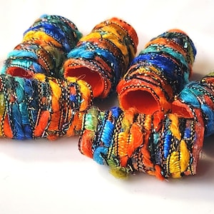 May include: Five colorful fabric covered hair rollers with orange centers and a variety of colors including blue, green, yellow, and orange.