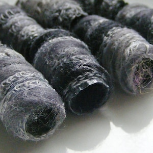 May include: Four gray and white felted wool yarn spools with a textured surface.