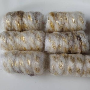 May include: Six cylindrical craft embellishments. Each is a creamy white color with gold metallic thread wrapped around it. The embellishments are arranged in two rows of three.