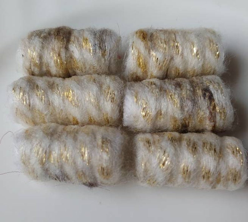 May include: Six cylindrical craft embellishments. Each is a creamy white color with gold metallic thread wrapped around it. The embellishments are arranged in two rows of three.