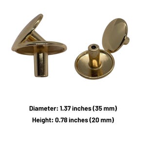 Pode incluir: Dois botões de armário dourados com topo redondo e base cilíndrica. Os botões medem 3,5 cm de diâmetro e 2 cm de altura.