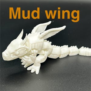 Op de afbeelding: Een witte, beweegbare drakenfiguur met de tekst "Mud wing" in oranje. De draak heeft een gedetailleerde kop, vleugels en een gesegmenteerd lichaam. De figuur staat op een donkere ondergrond.
